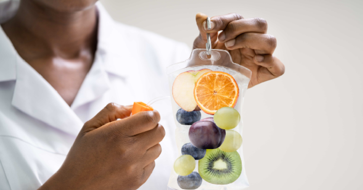 Close-up of a healthcare professional holding a vitamin-infused IV bag with fruits inside symbolizing nutrient-rich IV Therapy in Oklahoma Ci